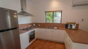 a kitchen with white cabinets and a stainless steel refrigerator at The Ponderosa Holiday House in Horseshoe Bay