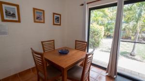 a dining room with a wooden table and a large window at The Ponderosa Holiday House in Horseshoe Bay +8 photos