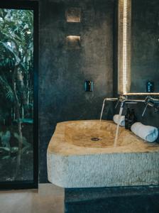 um lavatório de madeira na casa de banho com um espelho em Yum Kaax Boutique Villa em Tulum
