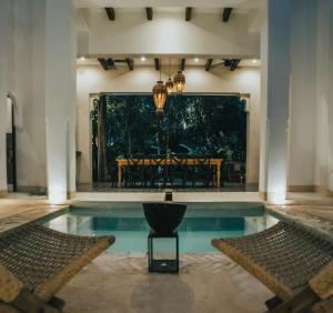 a pool in a house with a table and chairs at Yum Kaax Boutique Villa in Tulum