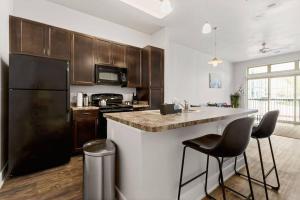 a kitchen with a black refrigerator and a counter at The Isabella: Riverwalk Loft in San Antonio