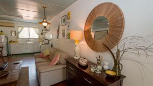 a living room with a couch and a mirror at Kismet Cottage Horseshoe Bay in Horseshoe Bay