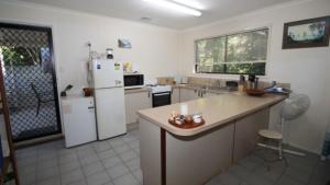 a kitchen with a white refrigerator and a counter at Seaward Cottage, Nelly Bay in Nelly Bay