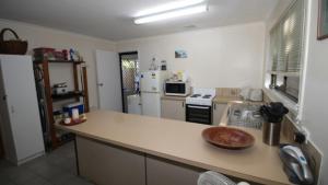 a kitchen with a counter top and a refrigerator at Seaward Cottage, Nelly Bay in Nelly Bay