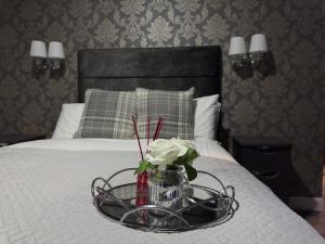 a glass tray with a vase of flowers on a bed at St Michaels Inn 