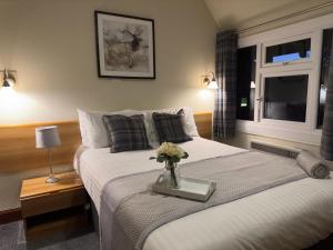 Un dormitorio con una cama con un jarrón de flores. en St Michaels Inn, 