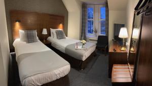 um quarto de hotel com duas camas e uma secretária em St Michaels Inn 