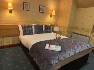 a bedroom with a bed with a tray with candles on it at St Michaels Inn 