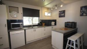a kitchen with white cabinets and a microwave and a counter at Breezeway On Horseshoe in Horseshoe Bay
