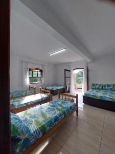 ein Zimmer mit drei Betten und einem Fenster in der Unterkunft Sitio Recanto da Alegria - MAIRINQUE in Mairinque + 63 Fotos