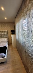 - une chambre avec un lit et un grand mur en verre dans l'établissement ComfortStyle, à Oviedo