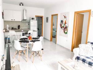 una cucina e un soggiorno con tavolo e sedie di CASA MIRAMAR a Corralejo