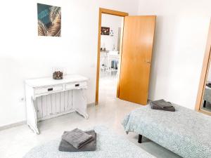 a white room with two beds and a wooden door at CASA MIRAMAR in Corralejo +10 photos