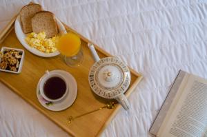 bandeja de desayuno con reloj, taza de café y libro en Apart Luna Salta en Salta