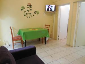 a living room with a green table and a tv at CHATAIGNE HEBERGEMENT in Petit-Bourg