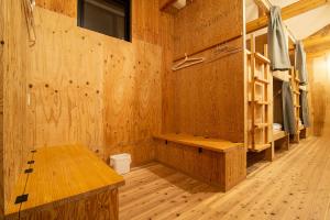 a room with wooden walls and a room with bunk beds at BED N CHILL Shippoya 七宝屋 in Mitoyo