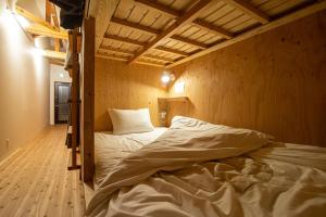 a bedroom with two bunk beds with white sheets at BED N CHILL Shippoya 七宝屋 in Mitoyo