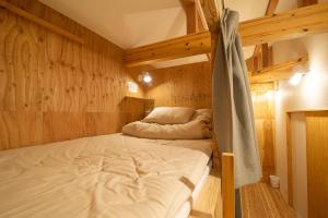 三豊市にあるBED N CHILL Shippoya 七宝屋の二段ベッドが備わる木製の壁の客室です。