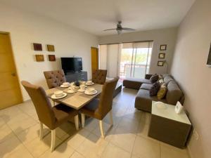 a living room with a table and a couch at Moderno condo de 1 rec con alberca 5 mins a playa 103b in Cabo San Lucas +14 photos