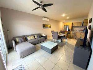 a living room with a couch and a ceiling fan at Moderno condo de 1 rec con alberca 5 mins a playa 103b in Cabo San Lucas