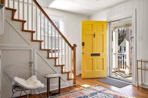 a yellow door in a hallway with a chair at Private House Mins to Maymont Park, Trails & VCU! in Richmond