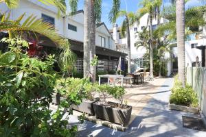 a courtyard with plants and a table and chairs at Resort Style Holiday in Hawks Nest