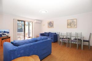 ein Wohnzimmer mit zwei blauen Sofas und einem Tisch in der Unterkunft Resort Style Holiday in Hawks Nest