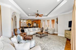 a living room with white furniture and a ceiling fan at Villa by the Sea in Destin