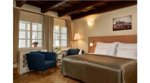 pokój hotelowy z łóżkiem i dwoma krzesłami w obiekcie Mostecká 12 Residence w Pradze