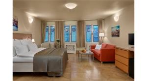 1 dormitorio con cama, sofá y ventanas en Mostecká 12 Residence en Praga