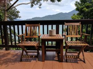 丽贝岛Cashewnut Cove的甲板上配有两张木椅和一张桌子