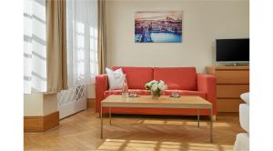 salon z czerwoną kanapą i stołem w obiekcie Mostecká 12 Residence w Pradze +16 zdjęć