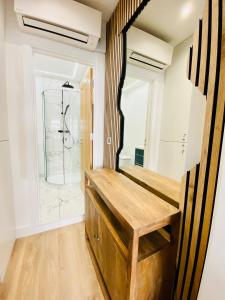 a bathroom with a shower and a wooden bench at New studio flat overlooking city centre in Kingston upon Thames