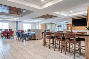a dining room with tables and chairs and a flat screen tv at Holiday Inn Express & Suites Vandalia, an IHG Hotel in Vandalia