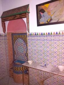 a bathroom with a tile wall with a fireplace at Dar Sam - Pacha Room in Rabat