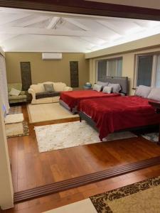 a bedroom with a large bed with a red blanket at Best Vacation rental house close to Kahala Beach ! in Honolulu