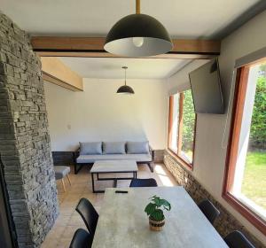 uma sala de estar com uma mesa e um sofá em Casa AICU em Villa La Angostura