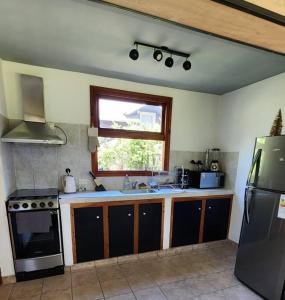 a kitchen with a sink and a stove and a window at Casa AICU in Villa La Angostura