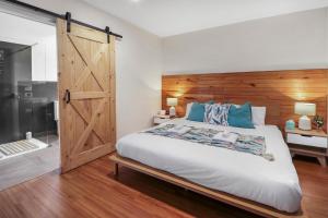 1 dormitorio con cama grande y puerta corredera de granero en Alpine Twin Heights, en Mansfield