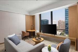 a living room with a couch and a large window at Metropark Hotel Hongqiao Shanghai in Shanghai