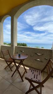 a table and chairs on a balcony with a view of the ocean at Sea Princess B&B in Fengbin