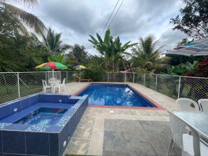 a swimming pool with a table and an umbrella at Casa Campestre El Encanto in Trujillo
