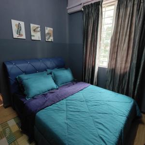 a bedroom with a bed with blue sheets and a window at Fayyadh Homestay Selayang - 3 Bilik 2 Bilik Air -malay only in Batu Caves