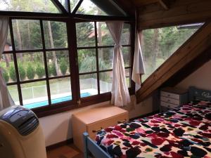 1 dormitorio con cama y ventana grande en Casa Carilo en Cariló