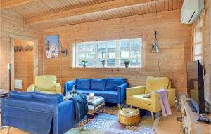 a living room with blue couches and yellow chairs at Cozy Home In Helsinge With Kitchen in Helsinge