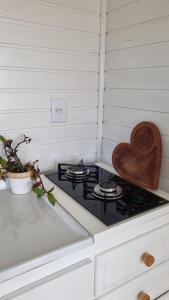 una estufa con un corazón de madera encima en A Casinha de Madeira en Balneário Gaivotas