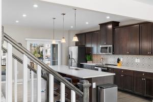 a kitchen with wooden cabinets and a kitchen island at New 4 Bedroom Townhouse at Barefoot Resort in North Myrtle Beach