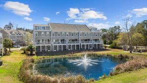 a large building with a pond in front of it at New 4 Bedroom Townhouse at Barefoot Resort in North Myrtle Beach