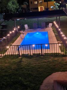 una piscina en un patio por la noche con luces en Don Mateo - Casa de Campo en Salta