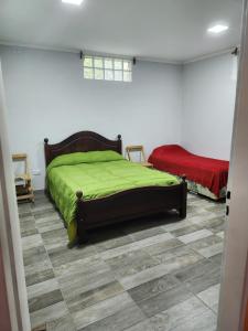 1 dormitorio con 1 cama con manta verde en Don Mateo - Casa de Campo en Salta